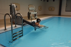 Una usuària del CEM Les Vernedes fa ús de la grua i la cadira per accedir al vas complementari de la piscina coberta.