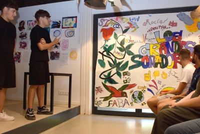 Un grup de joves mostrant el mural que han pintat.