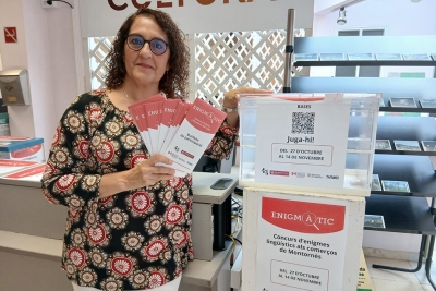 La tècnica municipal de Normalització Lingüística, Reyes Barragán, amb la imatge de promoció del concurs "Enigmàtic".