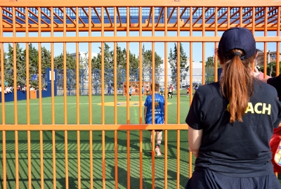 Una de les entrenadores (coach) mirant el partit de la seva escola.