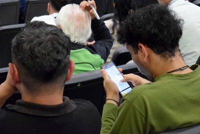 Un dels assistents seguint la informació des del seu telèfon mòbil. 