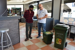 Un informador ambiental explica i verifica la correcta separació dels envasos de vidre a un establiment de Montornès.