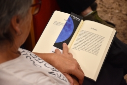 Una dona llegint a la celebració del Dia Mundial de les Biblioteques 2025 a Montornès.