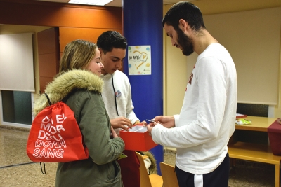 Dos joves de 4t d'ESO de l'Institut Vinyes Velles informen un dels donants de sang