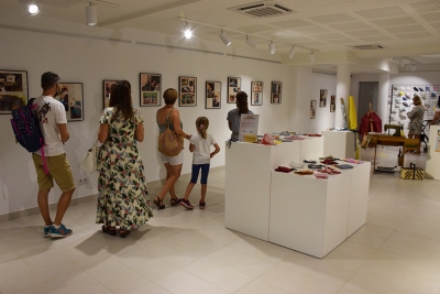 Visitants passegen per l'exposició "Teixint Solidaritat"