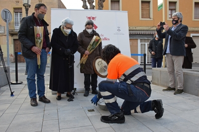 Familiars de les víctimes passen la llamborda a un operari de la Brigada que les ha col·locat