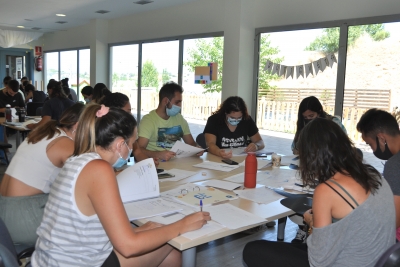 Un grup de monitors i monitores treballant per grups al Centre Infantil La Peixera