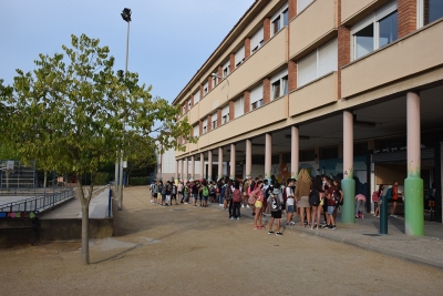 Els infants esperen, de manera esglaonada, per entrar a classe.