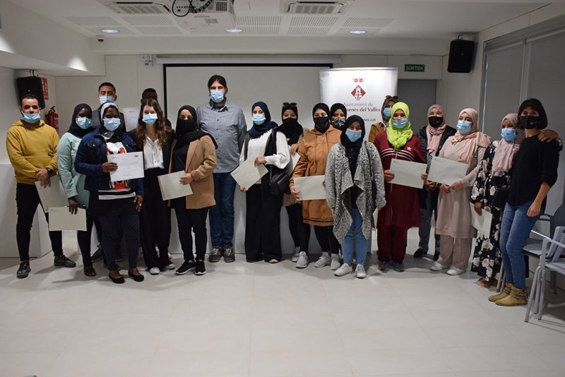 Participants en el darrer curs d'alfabetització amb el regidor de l'Àrea d'Acció Social, Jordi Delgado; la pedagoga i professora del curs, Judith Vázquez; i la tècnica municipal de Polítiques Migratòries, Anna Meca. 