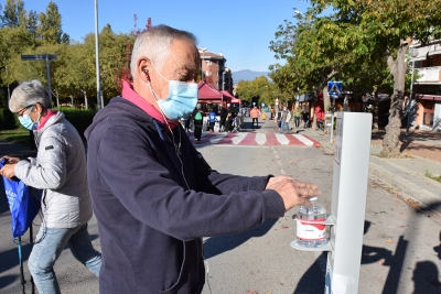 Un dels participants fa ús d'un dispensador de gel hidroalcohòlic a l'arribada de la Marxa Popular.