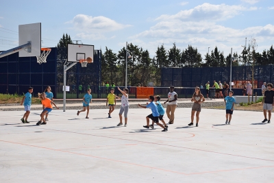 Nens i nenes del Casal de Vacances juguen a la nova pista de bàsquet.