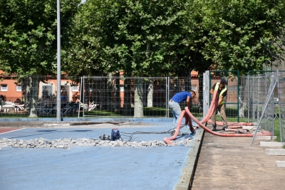 Dos operaris treballant en les pistes de tennis.