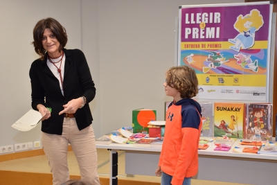 La directora de la Biblioteca, Glòria Catafal, amb un dels infants participants.