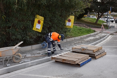 Operaris de la brigada municipal d'obres executant els treballs d'ampliació de la vorera.