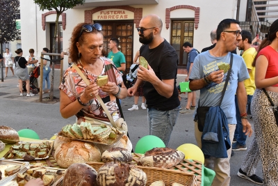 Veïns/es tastant el pa de la Festa Major 2025.