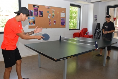 Joves jugant a tennis taula a l'agost al Centre Juvenil Sputnik.