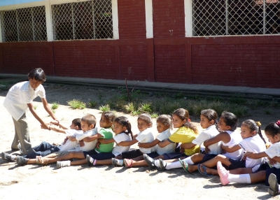 Infants jugant a "arrencar cebes". Escola Jiñocuao  